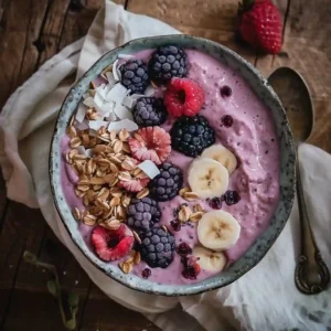 Served ube smoothie bowl with berries, almonds, and coconut flakes