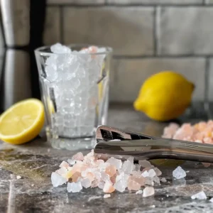 Adding lemon juice and pink salt into a glass of crushed ice