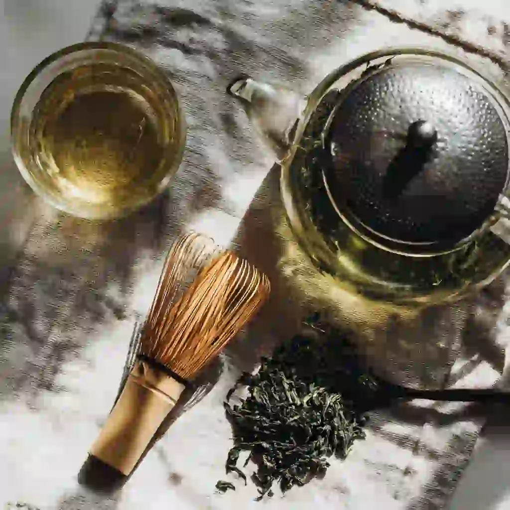 how to brew green tea_Green tea brewing tools and loose leaves on linen in a bright kitchen