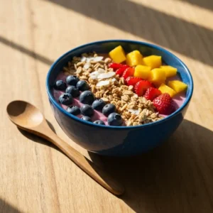 Homemade smoothie bowl with banana slices, blueberries, granola and coconut flakes